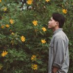 A man enjoying some wild flowers, gifting flowers for men can bring them the same enjoyment and mood improvement